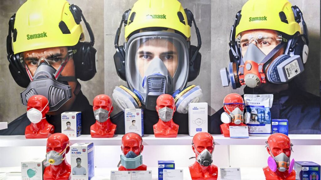 Feira sobre segurança de trabalho com amostrador com produtos de capacetes e máscaras especiais